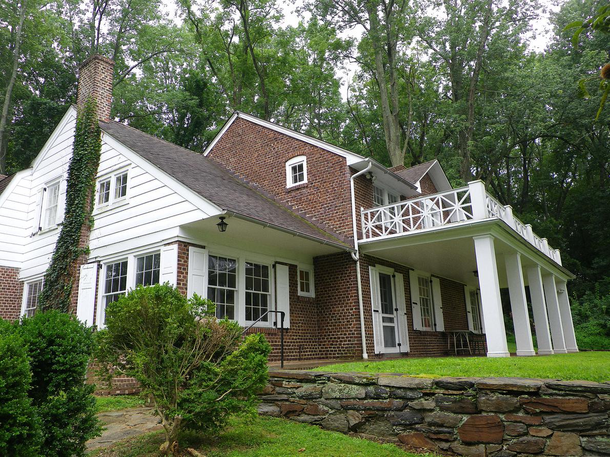The Wyeth house in Chadds Ford, stone with a white portico and a low wall along the road.
